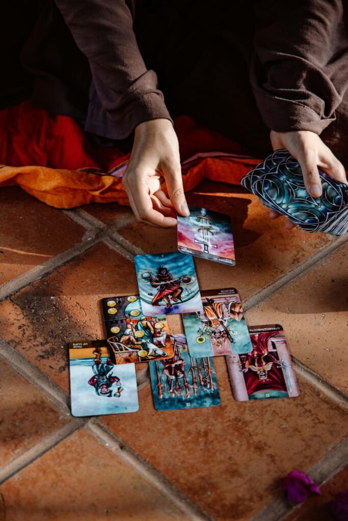 A close-up view of hands engaged in a tarot card reading on a tiled floor, creating a mystical atmosphere.